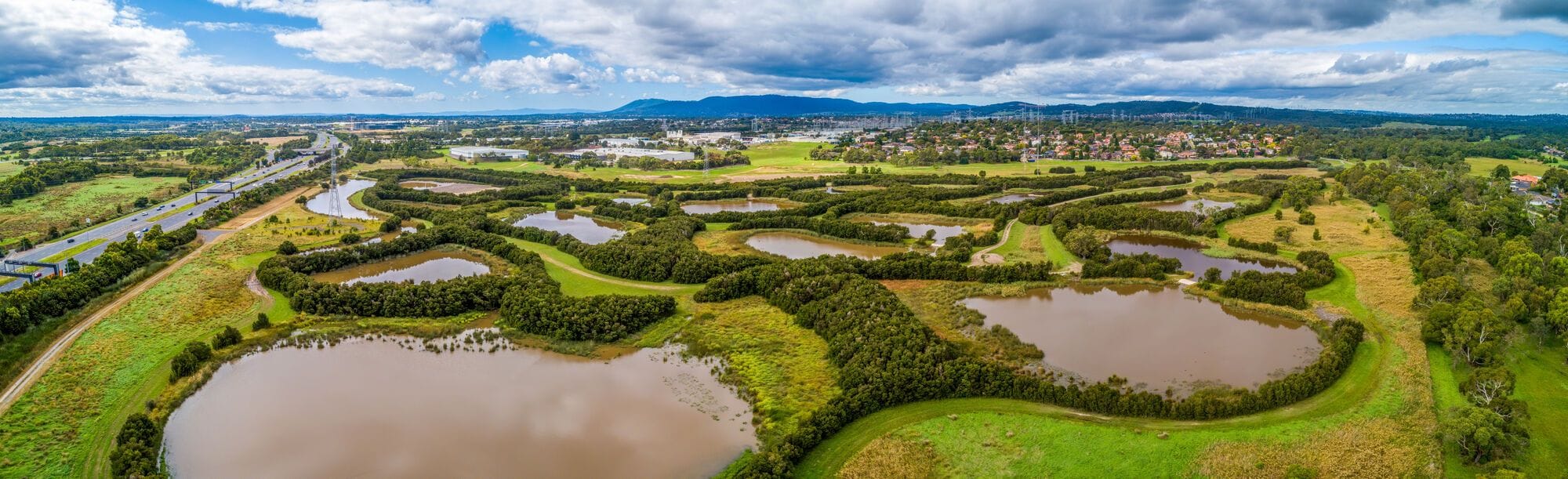 Vue aérienne des zones humides artificielles et de la végétation environnante.